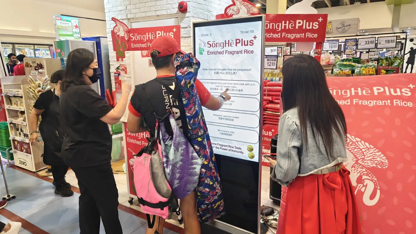 A family playing a quiz game at a supermarket roadshow kiosk